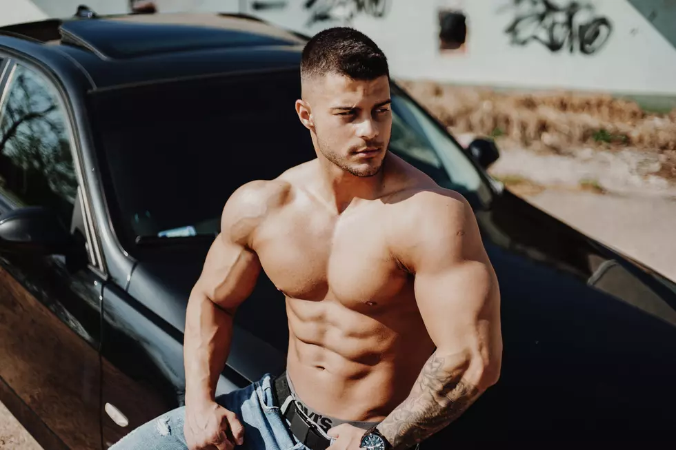 A person standing next to the car shirtless