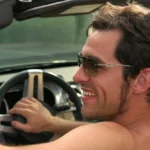 a person driving car shirtless